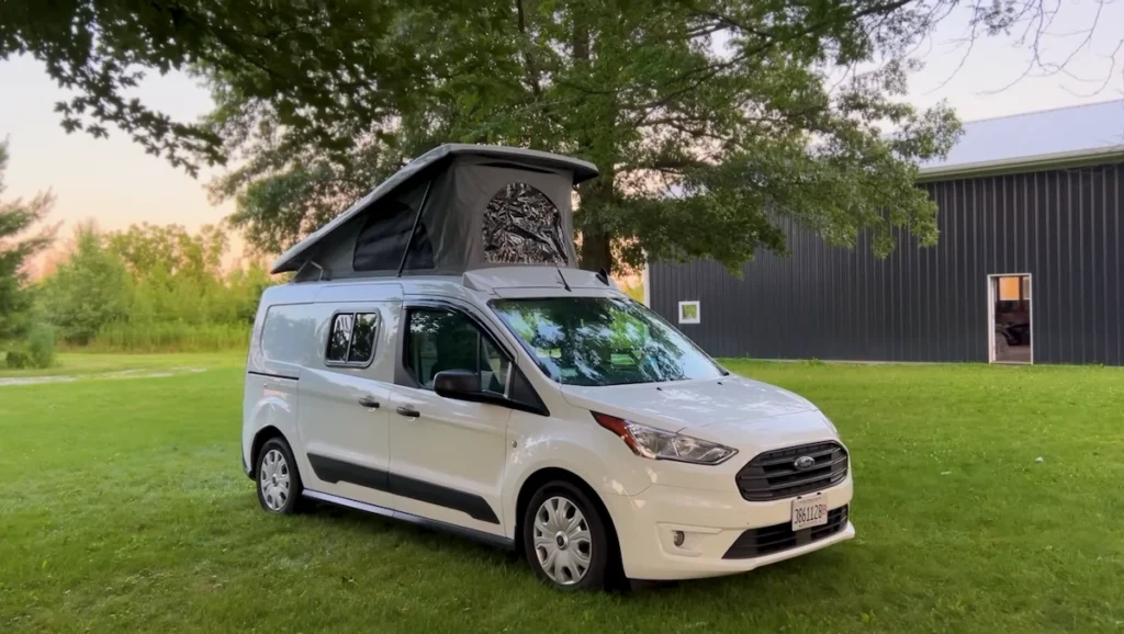 A photo of a Ford Transit Connect (XLT) converted to camper van with full off grid van life set up.