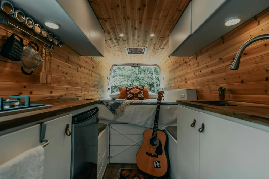 A photo of a cozy interior inside a high-roof cargo van converted for van life with full off grid set-up.